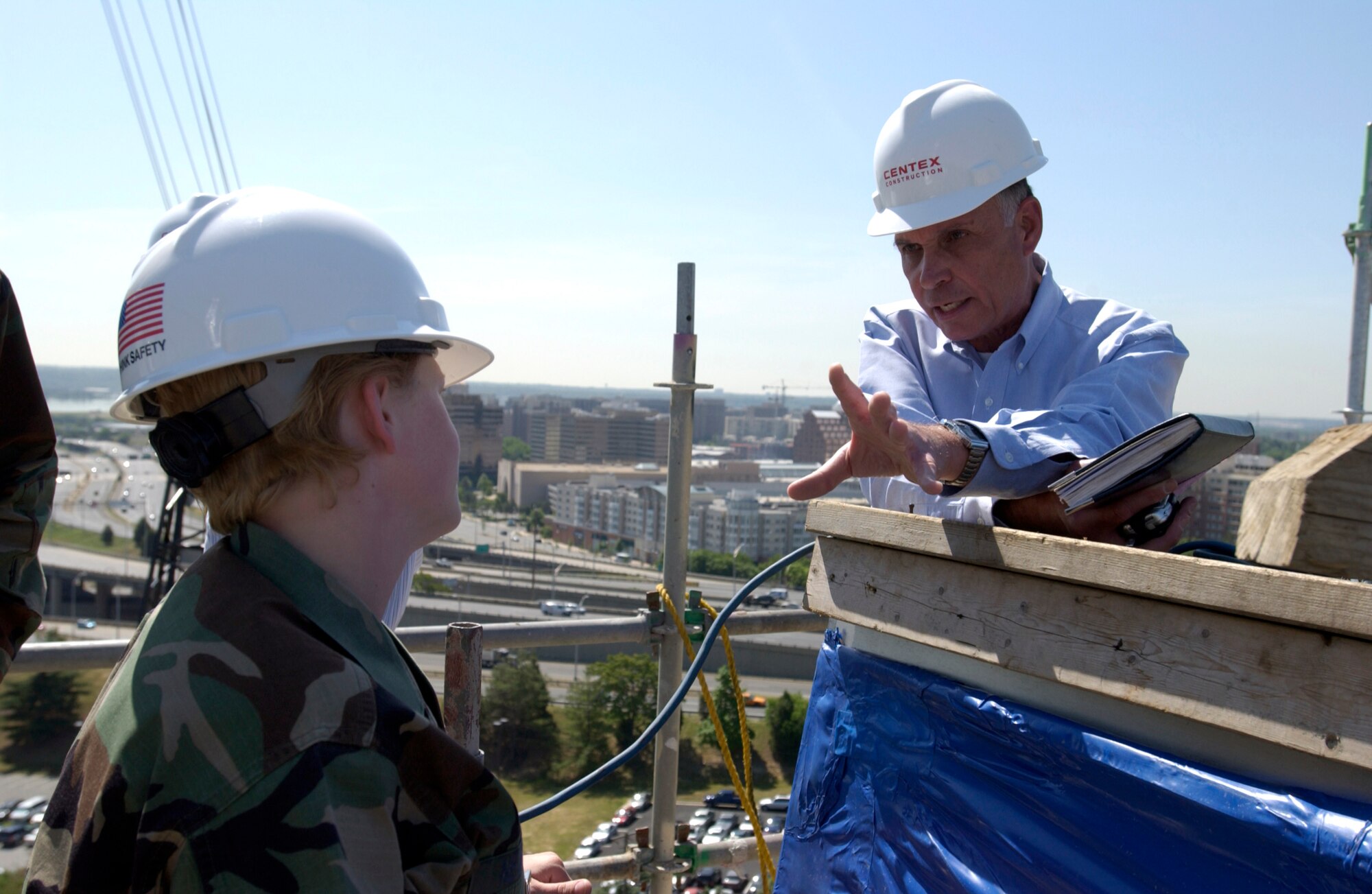 Retired Maj. Gen. Edward F. Grillo Jr. talks with Staff Sgt. Paula Newman about the new Air Force Memorial from atop the scaffolding surrounding one of the memorial's spires. Three spires will represent the Air Force core values. The memorial is scheduled for completion in October. General Grillo is president of the Air Force Memorial Foundation. Sergeant Newman is assigned to the 11th Logistics Readiness Squadron at Bolling Air Force Base in Washington, D. C. (U.S. Air Force photo/Tech. Sgt. Cohen A. Young) 
