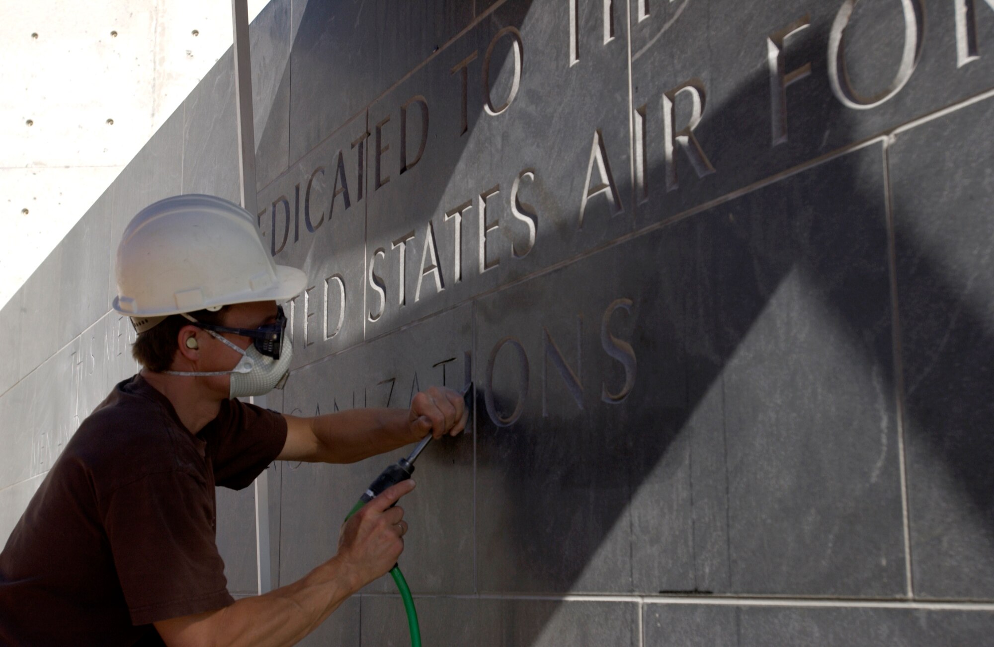 Contractor Marcel Machler chisels lettering at the Air Force memorial being built in Arlington, Va.. The memorial will be complete in October, and have three spires representing the core values: integrity first, service before self and excellence in all we do. (U.S. Air Force photo/Tech. Sgt. Cohen A. Young)
