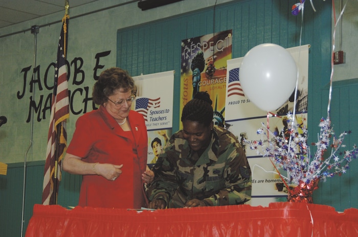 Technical Sgt. Shanell Wingate, 99th Mission Support Squadron, signs her Troops to Teachers contract with the Clark County School District, Clark County, Nev. Assisting Sergeant Wingate is Dr. George Anne Rice, the district's associate superintendent of human resources. (U.S. Air Force Photo/Staff Sgt. Julie Parker)