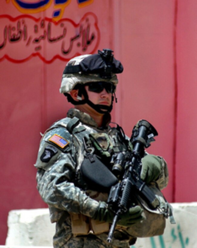U.S. Army 1st Lt. Jason Hehl provides security for soldiers of the 310th Psychological Operations Company as they talk with shop owners in the city of Samarra, Iraq, during a patrol on June 14, 2006. Hehl is an S-4 officer for 3rd Battalion, 187th Infantry Regiment, 3rd Brigade Combat Team, 101st Airborne Division. 