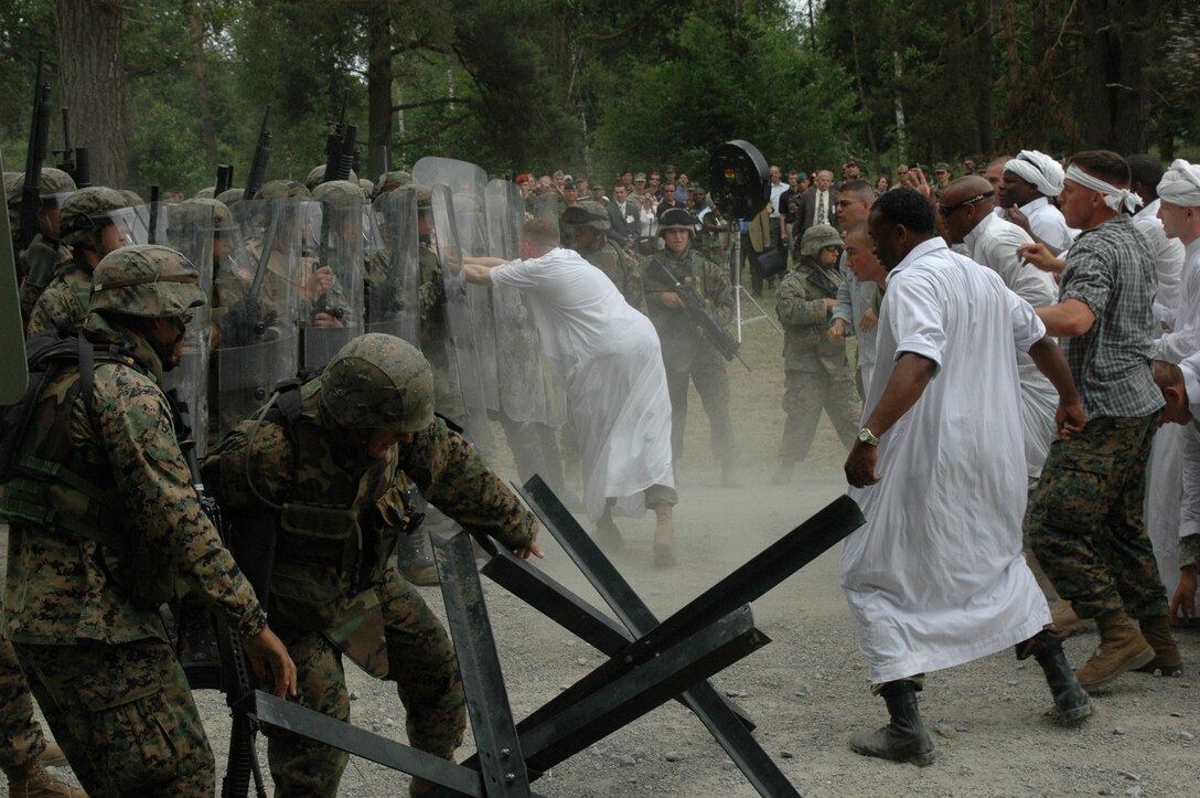 BOEBLINGEN, Germany ? Marines and soldiers employ non-lethal weapons and tactics for more than 100 attendees during the U.S. European Commands Non-lethal Capabilities Exercise here June 21. Hosted by U.S. Marine Corps Forces Europe, the program?s executive agent, the exercise focused on current and emerging non-lethal weapons systems and techniques.  Marines assigned to 2nd Platoon, Marine Corps Security Forces Company from Rota, Spain and soldiers assigned to 1st Armored Division; 1st Battalion, 10th Special Forces Group (Airborne)  and the Joint Multinational Readiness Command participated in the exercise. (Photo by Gunnery Sgt. Donald E. Preston)