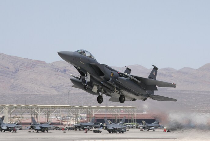 An F-15E Strike Eagle fighter takes off from Nellis Air Force Base, Nev. The aircraft is assigned to the 422nd Test and Evaluation Squadron, which conducts operational tests for Air Combat Command on new hardware and upgrades in a simulated combat environment. The 422nd also develops and publishes new tactics. (Photo courtesy Paul Ridgway, Typhire Photography)