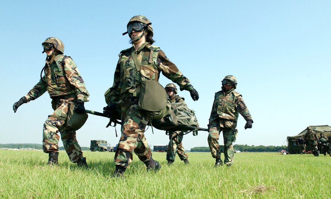 Airmen carry a litter of equipment from the mobile aeromedical staging facility to a C-130 Hercules at Augusta Regional Airport, Ga., on Saturday, June 17, as part of Golden Medic 2006. The annual medical exercise involves medical servicemembers from various military branches, including the Air Force and Army this year. (U.S. Air Force photo/Staff Sgt. Stephen Schester) 