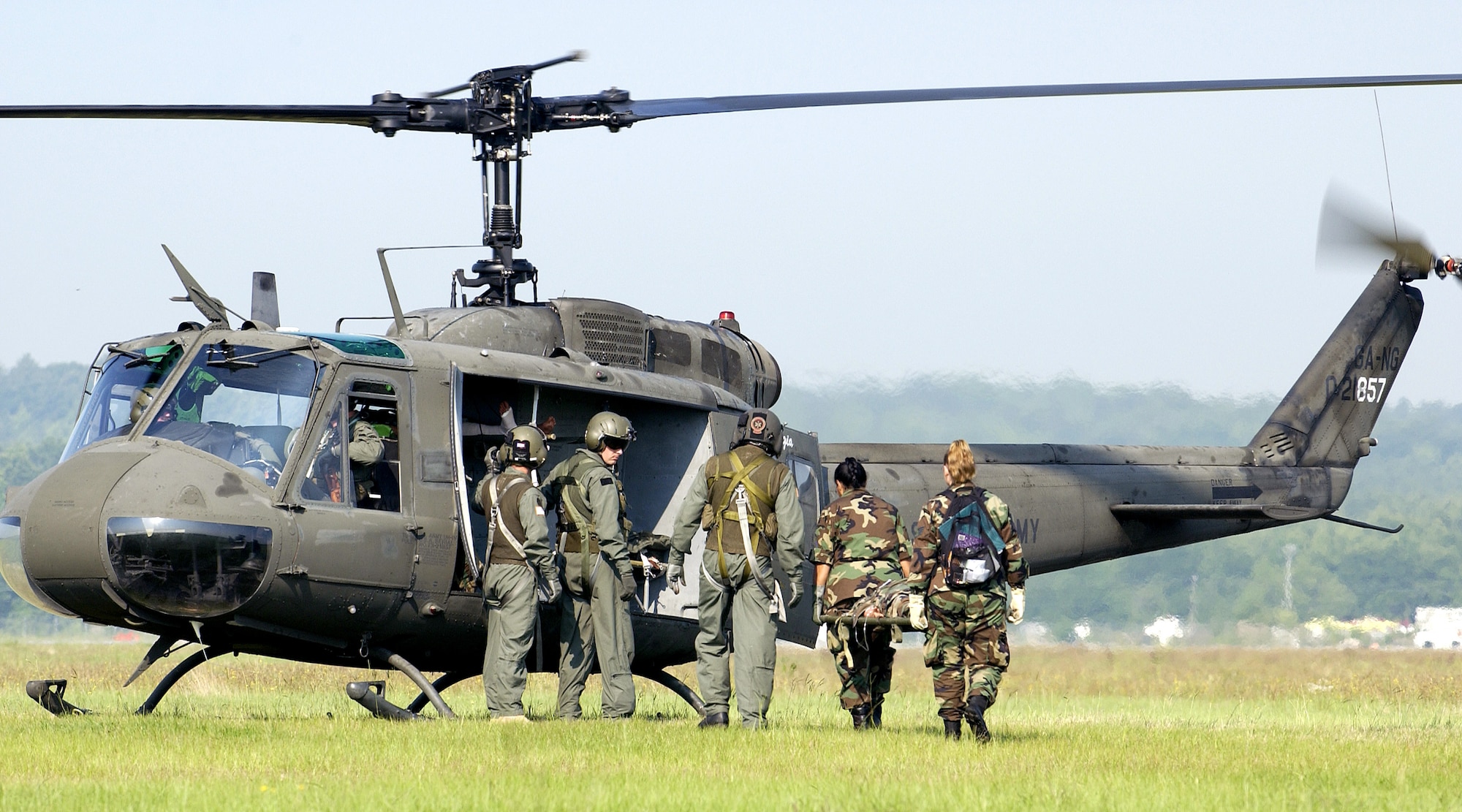 Two Airmen carry a litter with a mannequin patient to an Army UH-1 Huey for transport to the contingency aeromedical staging facility at Augusta Regional Airport, Ga., on Saturday, June 17, as part of Golden Medic 2006. The annual medical exercise involves medical servicemembers from various military branches, including the Air Force and Army this year. (U.S. Air Force photo/Staff Sgt. Stephen Schester) 
