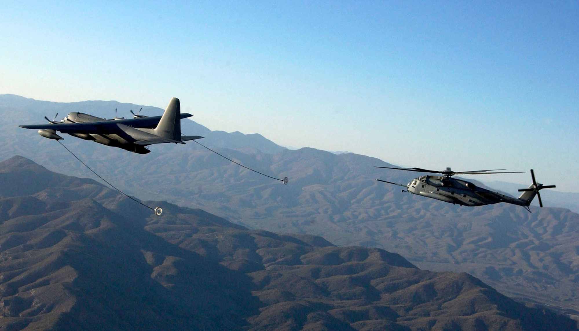 An HC-130 from the 79th Rescue Squadron at Davis-Monthan Air Force Base, Ariz., refuels a CH-53E Super Stallion helicopter from the Marine Heavy Helicopter Squadron 769 at Edwards Air Force Base, Calif. The CH-53Es are here training with Airmen as part of Davis-Monthan's joint operations training. (U.S. Air Force photo/Airman 1st Class Veronica Pierce) 