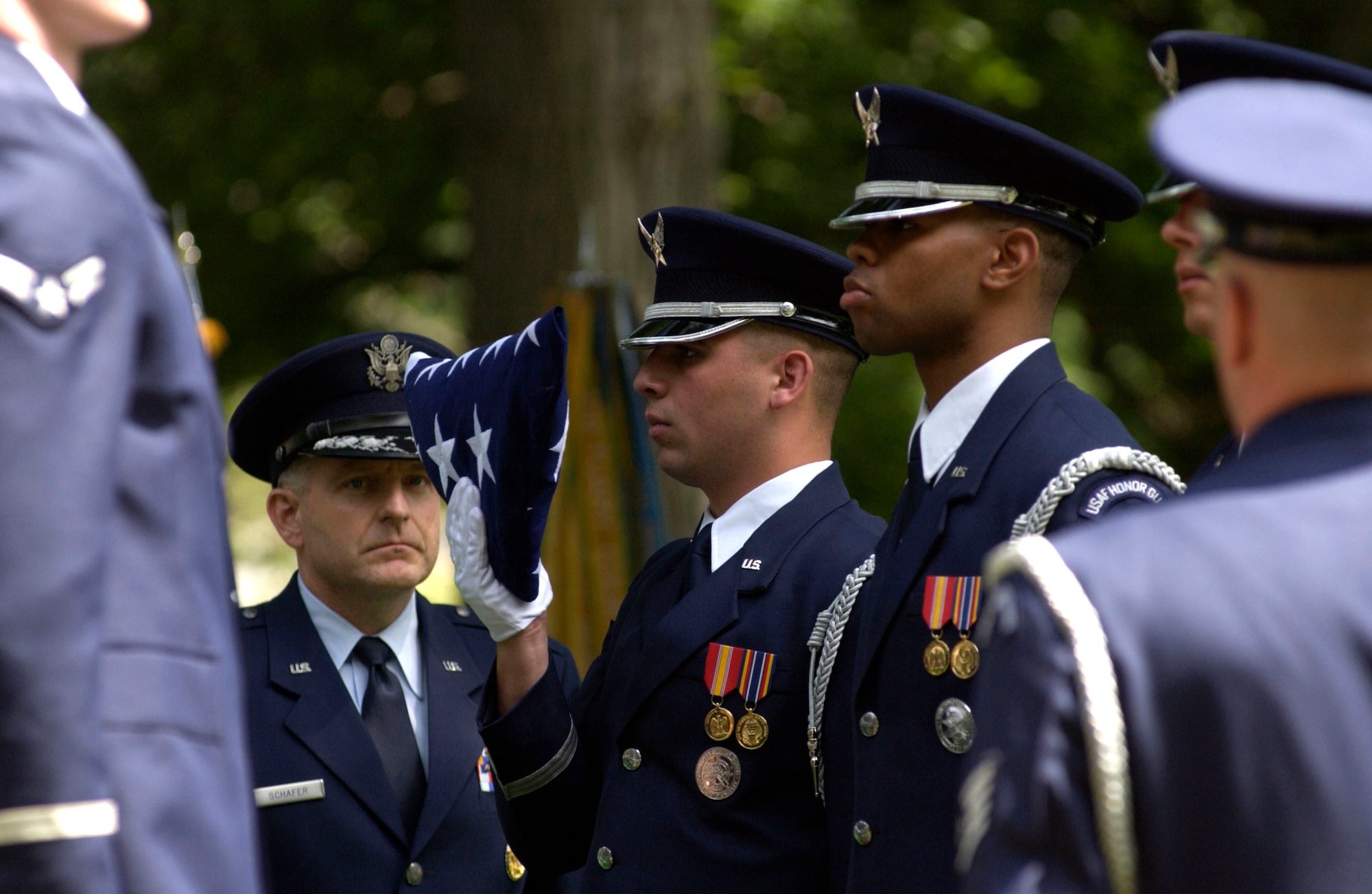 Brig. Gen. Paul Schafer waits for the flag to be passed to him by a member of the Air Force Honor Guard at the funeral for Staff Sgt. Calvin Cooke Jr. at Arlington National Cemetery in Arlington, Va., on Tuesday, June 20. Sergeant Cooke, a C-130 Hercules loadmaster, died in April 1972 when his aircraft crashed in South Vietnam after being hit by ground fire. His remains were identified last month by experts at the Joint Prisoner of War/Missing in Action Accounting Command headquarters. General Schafer is director of the special programs office for the under secretary of defense for acquisitions, technology and logistics. (U.S. Air Force photo/Tech. Sgt. Cohen A. Young) 
