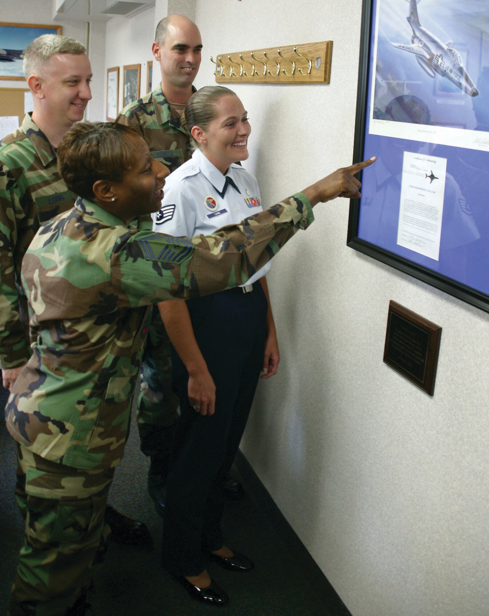 20th Communications Squadron volunteers along with an Airman Leadership School instructor admire the Voodoo legacy decor in an ALS classroom.  (U.S. Air Force Photo/Senior Airman John Gordinier)