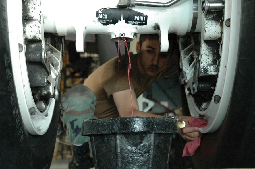 MINOT AIR FORCE BASE, N.D. --- Airman 1st Class Armando Williams, 5th Aircraft Maintenance Squadron crew chief, drains a strut on a B-52H Stratofortress during a phase inspection at the Phase Dock. (photo by Airman 1st Class Ross Tweten) (cleared by Airman 1st Class Ross Tweten)