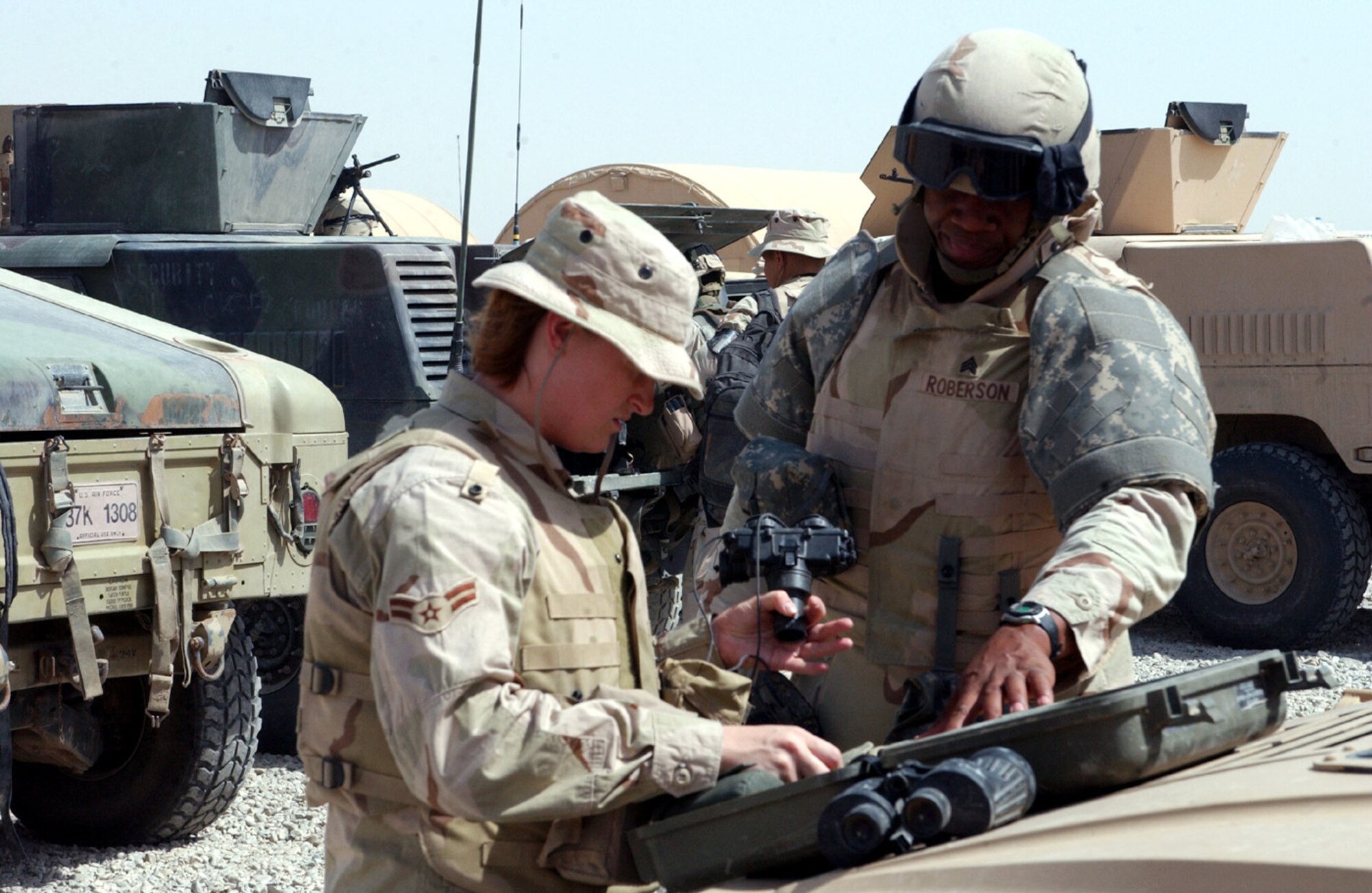 Airman 1st Class Shasta Williams and Army Sgt. Jonathan Roberson inventory equipment before heading out on a patrol at Ali Base, Iraq, on Friday, June 16. (U.S. Air Force photo/Master Sgt. Andrew Gates) 


