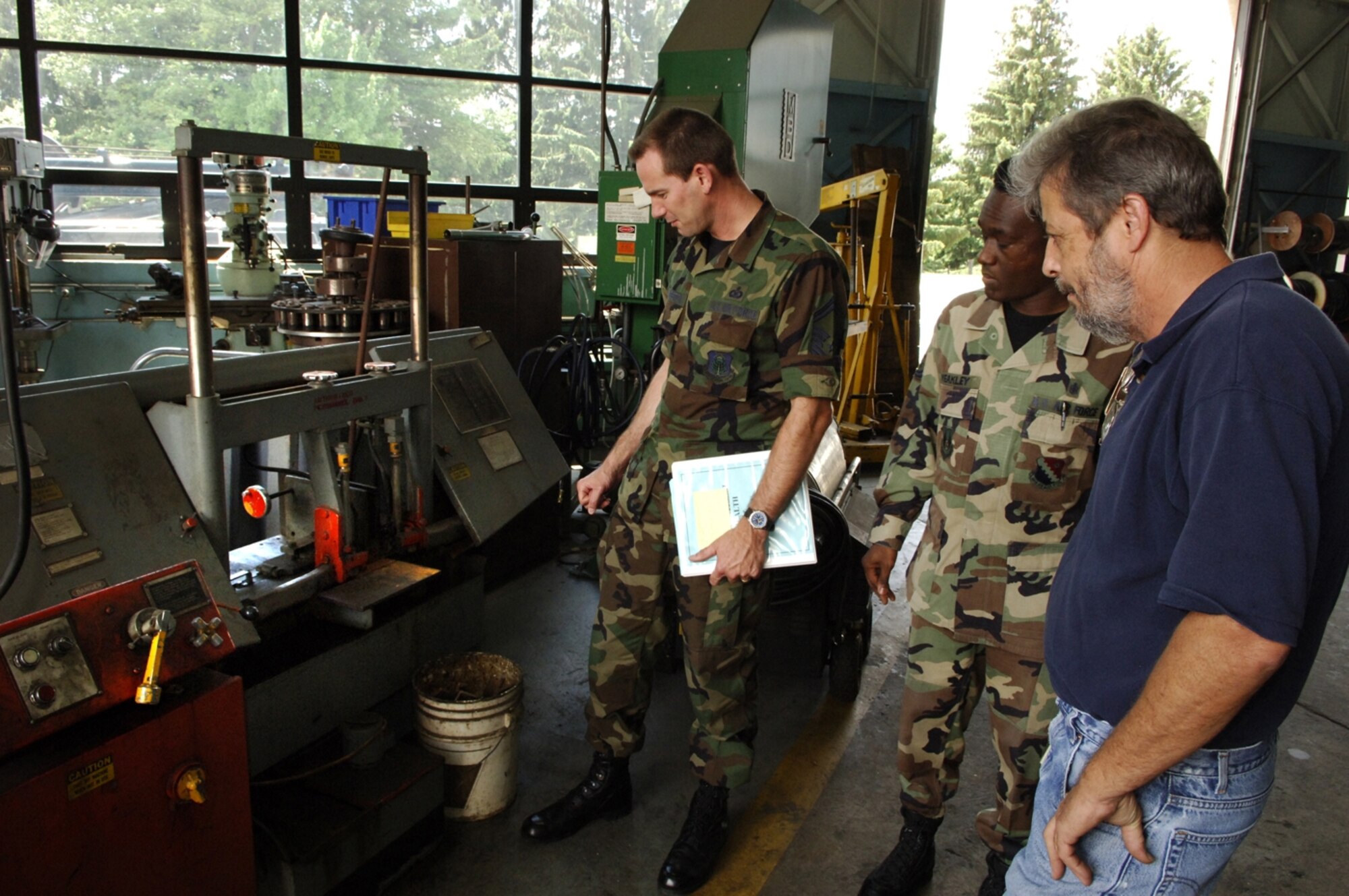 HANSCOM AIR FORCE BASE, Mass.— Left, from left, Senior Master Sgt. Scott Livingston, Electronic Systems Center Safety Office superintendent; Tech. Sgt. Michael Weakley, 66th Medical Operations Squadron; and John Sharpe, 66th Mission Support Group Logistics Readiness Division; check the vehicle maintenance facility during the recent Environmental Safety Occupational Health Compliance Assessment Management Program. (Air Force photo by Mark Wyatt)

