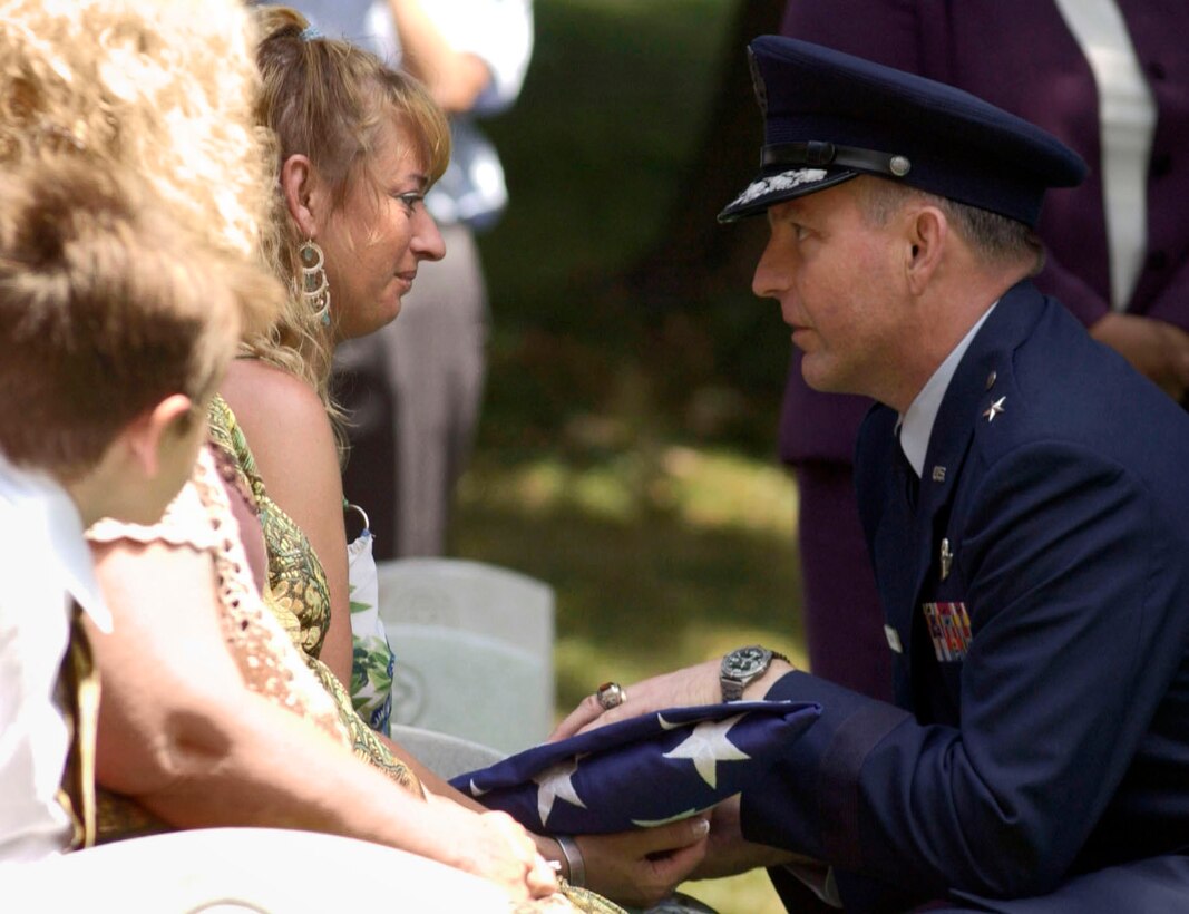 Brig. Gen. Paul Schafer presents the U.S. flag to Angela Cooke at the funeral for her father, Staff Sgt. Calvin Cooke Jr., at Arlington National Cemetery in Arlington, Va., on Tuesday, June 20. Sergeant Cooke died in April 1972 when his aircraft was shot down in South Vietnam. (U.S. Air Force photo/Tech. Sgt. Cohen A. Young) 