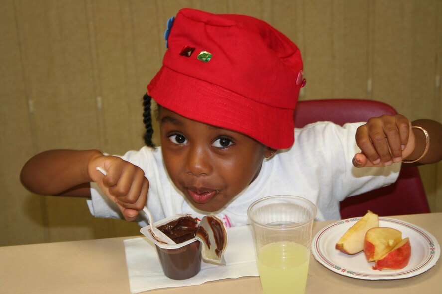 A VBS child enjoys an evening snack before the treasure hunt.