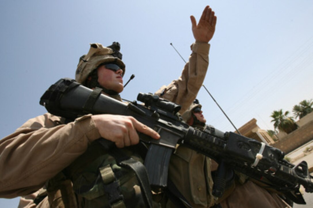 U.S. Marine Corps Lance Cpl. Brandon R. Musser motions for Iraqi civilians to step out of their car before searching it during a snap vehicle checkpoint patrol in the city of Ramadi, Iraq, on June 20, 2006. The objective of the patrol is to deny insurgents the ability to freely move throughout the city of Ramadi. Musser is attached to Lima Company, 3rd Battalion, 8th Marine Regiment. 
