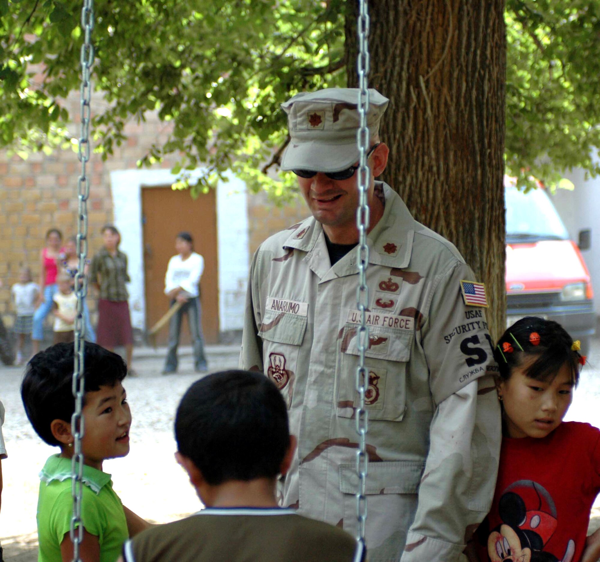 Maj. Mark Anarumo, 376th Expeditionary Security Forces Squadron, speaks to Oktobersky Village, Kyrgyzstan children during the dedication of a new children's playground at their school. Major Anarumo and members from the 376th Air Expeditionary Wing at Manas Air Base, Kyrgyzstan, were on hand to dedicate the playground, built by members of the 376th ESF and Civil Engineer squadrons. Major Anarumo is deployed from the 43rd Security Forces Squadron, Pope Air Force Base, N.C.(U.S. Air Force photo/Staff Sgt. Candy Knight) 