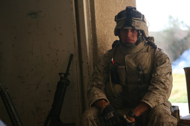 Lance Cpl. Joshua J. Henderson, a native of Conroe, Texas, pauses for a moment while he, and four other Marines with Combat Logistics Detachment 115, aid the Army's 1st Brigade, 1st Armored Division with increased security operations in the violence-ridden city of Ramadi. Ramadi has seen a flurry of insurgent activity this year and has been the focus of worldwide attention as Operation Iraqi Freedom persists in its third year. The detachment, part of Combat Logistics Regiment 15 at nearby Camp Taqaddum, was recently mobilized to help the Army's 1st Brigade, 1st Armored Division build several outposts in the city. The goal of the operation is to establish a presence of Coalition and Iraqi Security Forces in areas previously controlled by the enemy.  Multiple outposts have been constructed thus far, and Ramadi General Hospital has been cleared of any insurgent activity or presence. (Official USMC photograph by Cpl. Daniel J. Redding. 060626-M-7799R-014. Released.)