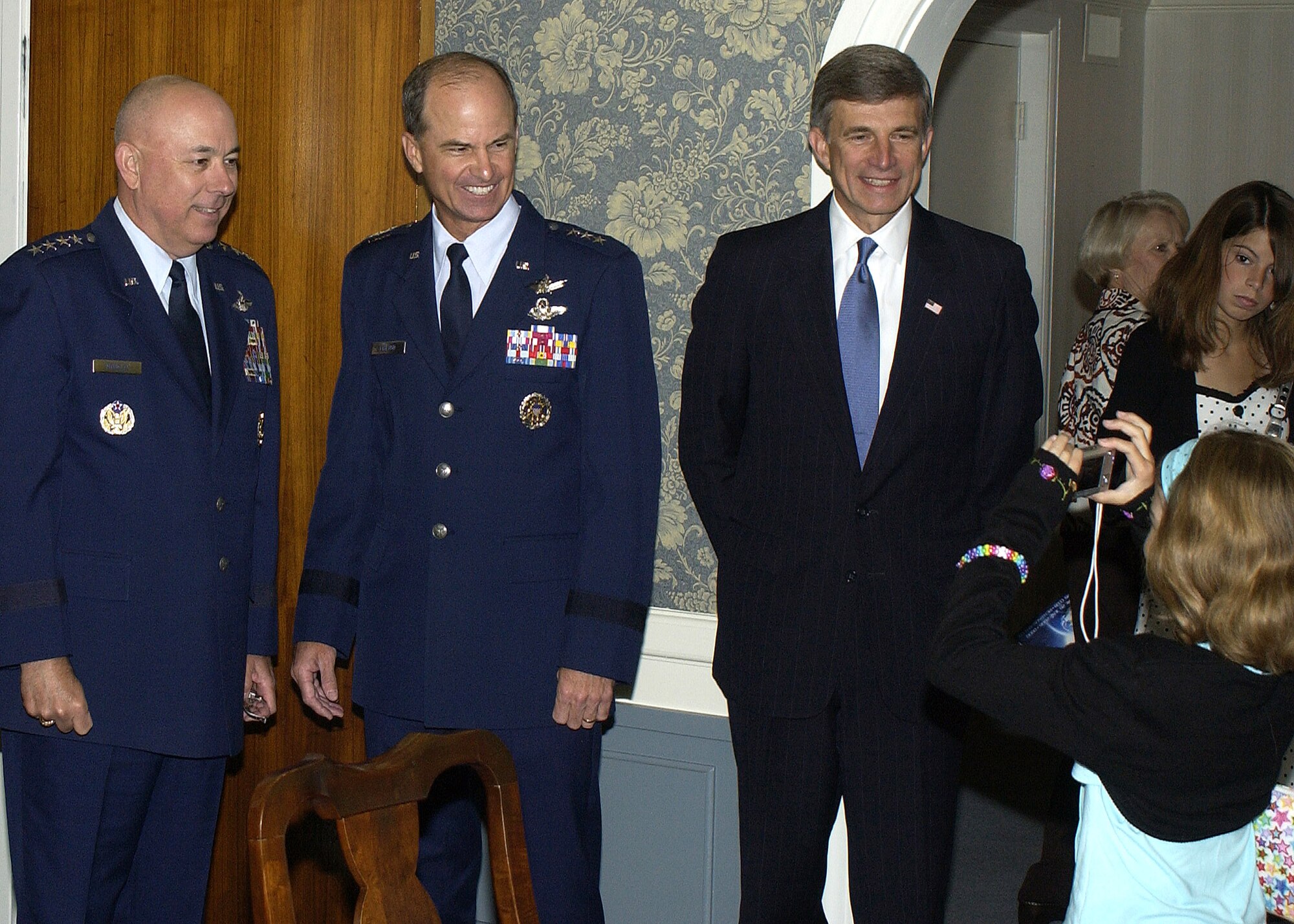 Gen. Kevin P. Chilton's youngest daughter, Morgan, snaps a quick photograph of her father with Air Force Chief of Staff Gen. T. Michael Moseley and Dr. Ronald Sega, undersecretary of the Air Force, just before the general assumes command of Air Force Space Command at Peterson Air Force Base, Colo., on Monday, June 26. (U.S. Air Force photo by Duncan Wood) 


