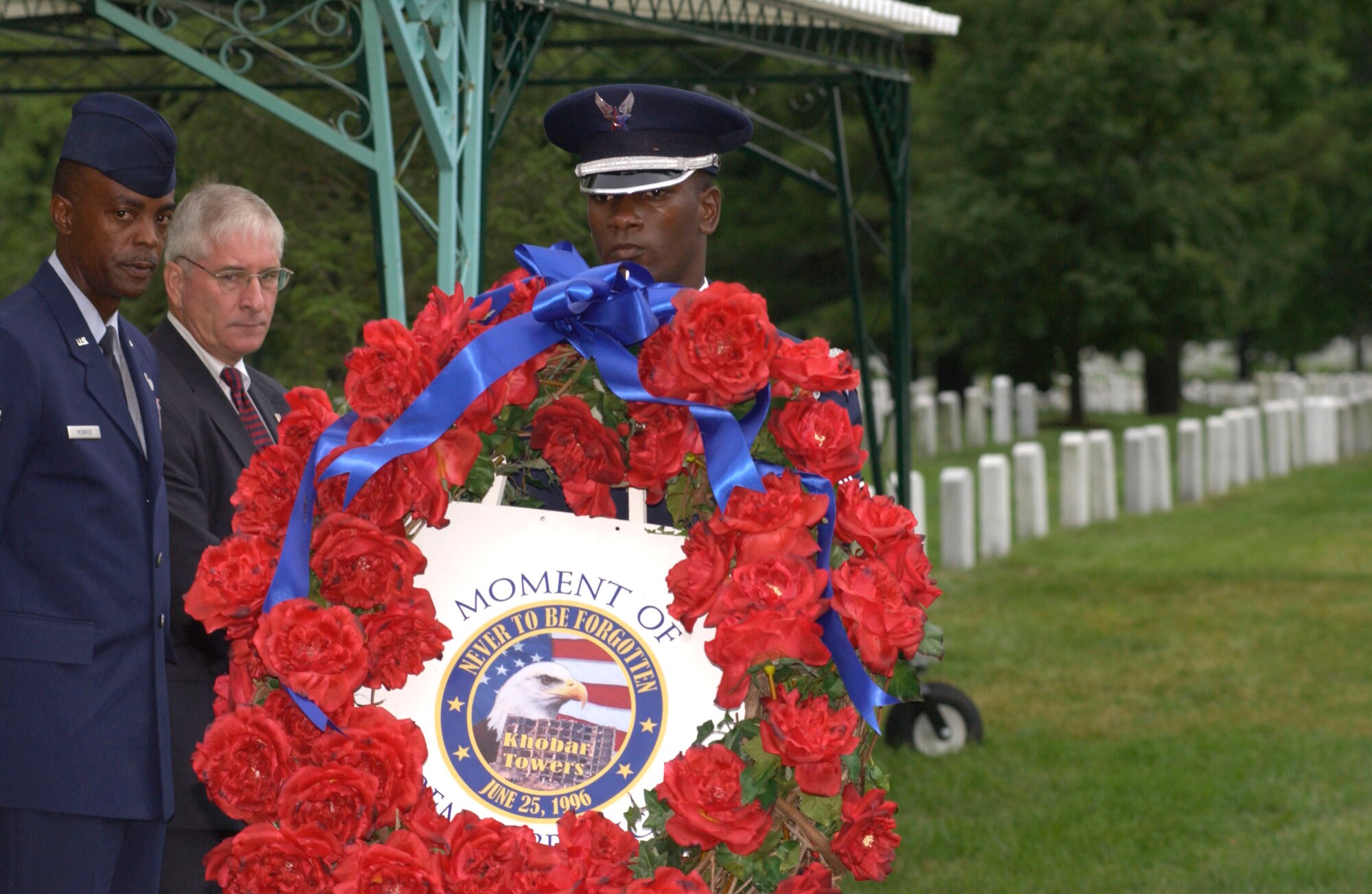 U.S. Air Force Honor Guard member Senior Airman Jarvis Warthen carries the ceremonial wreath to be placed at the headstones of Master Sgt. Michael George Heiser and Airman 1st Class Brian McVeigh during the remembrance ceremony of the Khobar Towers bombing on Sunday, June 25, at Arlington National Cemetery, Va. Family members and friends of the 19 Airmen killed in the terrorist bombing at Dhahran Air Base, Saudi Arabia, on June 25, 1996, gathered for the ceremony. (U.S. Air Force photo/Tech. Sgt. Cohen A. Young) 