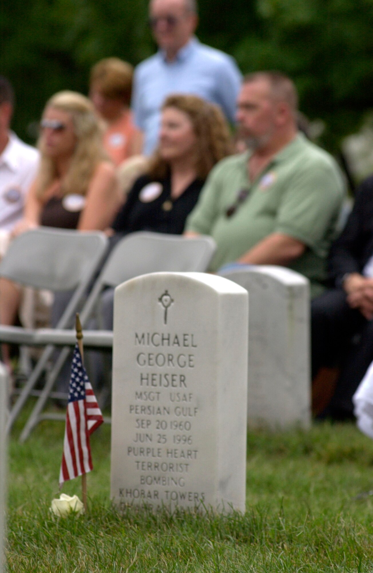 The headstone of Master Sgt. Michael George Heiser rests at Arlington National Cemetery, Va., near family members and friends gathered at a remembrance ceremony on Sunday, June 25, marking the 10th anniversary of the Khobar Towers bombing.  Nineteen Airmen were killed in the terrorist bombing at Dhahran Air Base, Saudi Arabia, on June 25, 1996.   (U.S. Air Force photo/Tech. Sgt. Cohen A. Young) 
