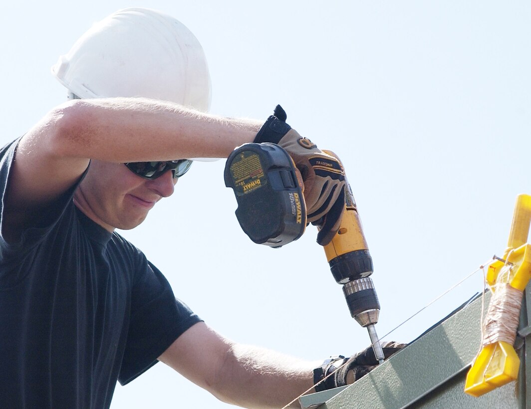 PETERSON AIR FORCE BASE, Colo. (AFRC) - Senior Airman Chad Kleger, 302nd Civil Engineer Squadron pavements and cosntruction equipment apprentice, fastens down a sheet of roofing material at the Aloha Gardens construction site. The 302nd CES went to Hawaii in May and June during its anual tour to construct buildings for Anuenue Hale, Inc., a non-profit organization which provides short-term respite care facilities and homes for elderly, handicapped and economically disadvantaged citizens. (U.S. Air Force photo by Tech. Sgt. Tim Taylor)               