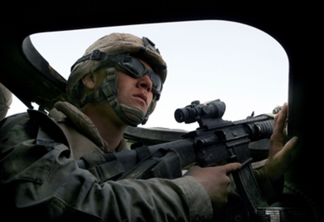 U.S. Marine Pfc. Gary M. Cassen, 18, a scout from Colfax, Calif., keeps an eye on the road for any insurgent activity while riding in the back of a light armored vehicle. Marines of D Company, 3rd Light Armored Reconnaissance Battalion, ran security and stability operations in Habbaniyah, Iraq, in support of 3rd Battalion, 5th Marine Regiment.