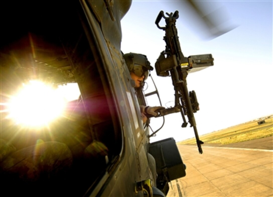 U.S. Army Pfc. Jordan Williams, a UH-60 Blackhawk crew chief for 1st Battalion, 207th Aviation Regiment with the Alaska National Guard, clears the helicopter for landing after an aerial traffic control point mission near Tall Afar, Iraq, June 5, 2006.