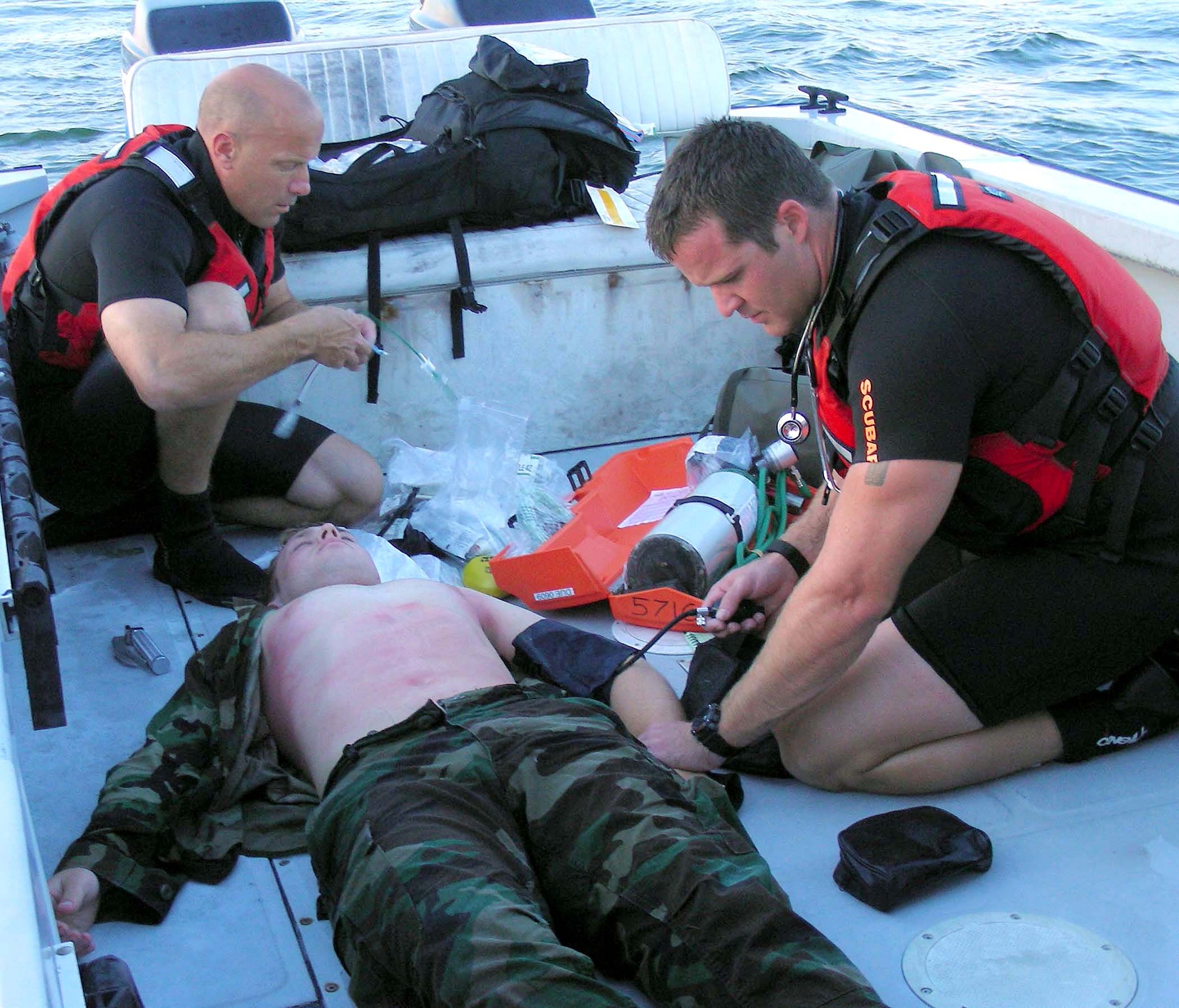 Staff Sgt. Russell Drake and Master Sgt. James Johnston simulate administering medical care to Senior Airman Andy Holzem aboard a Zodiac boat on the Banana River near Patrick Air Force Base, Fla., on Friday, June 23. The three Airmen, assigned to the 920th Rescue Wing, were training in open water rescue and recovery techniques to prepare them for space shuttle launch recovery support. (U.S. Air Force photo/1st Lt. Cathleen Snow)
