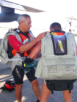 After donning and adjusting his own parachute, Master Sgt. Alexander Abbey checks a fellow pararescueman's parachute before boarding an HC-130P/N on Friday, June 23, at Patrick Air Force Base, Fla. The pararescuemen, assigned to the 308th Rescue Squadron, were training in open water rescue and recovery techniques to prepare them for space shuttle launch recovery support. (U.S. Air Force photo/1st Lt. Cathleen Snow)
