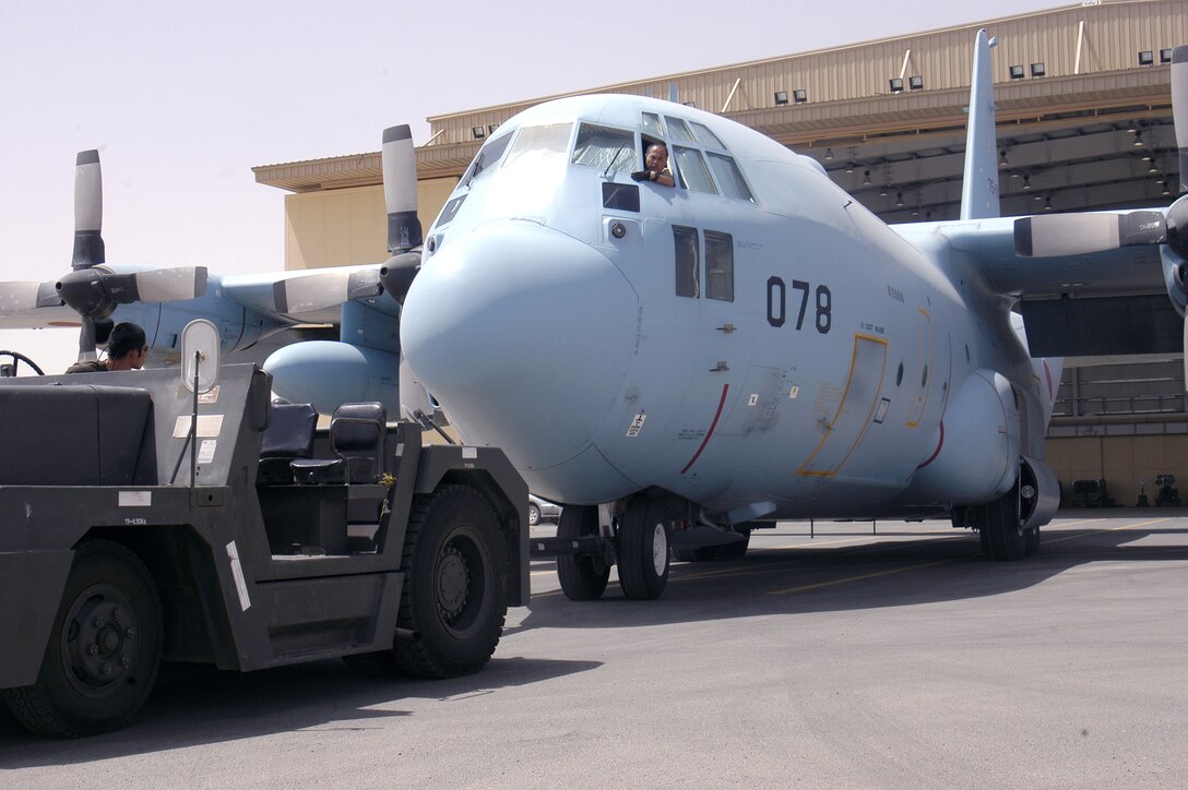 Maintainers from the Japan Air Self-Defense Force's Iraq Reconstruction Support Airlift Wing push one of their C-130s into a hangar at a forward operating base in Southwest Asia. (U.S. Air Force photo/Staff Sgt. Ryan Hansen) 