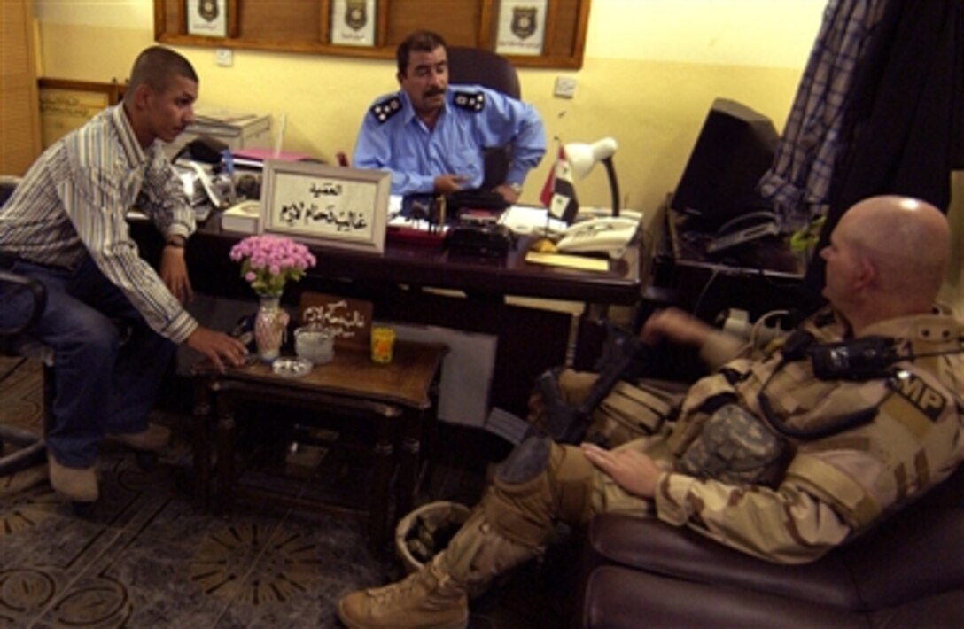 U.S. Army Sgt. 1st Class Mark Braley of the Oklahoma National Guard and a member of the Police Training Team at Camp Echo, Iraq, uses a translator, May 22, 2006, to chat with Brig. Gen. Ghalib Deham Lazim of the Ad-Diwaniyah Iraqi Police about recent mortar attacks against Coalition forces at Camp Echo.