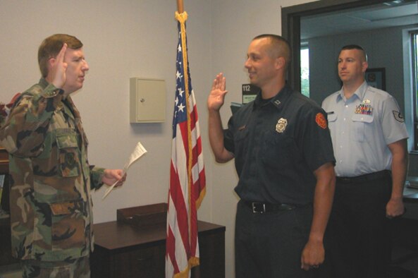 GRISSOM AIR RESERVE BASE, Ind., --- Clayton J. Duncan (center), a captain with the Kokomo, Ind., Fire Department, takes the oath of enlistment during a ceremony at Grissom ARB.  Lt. Col. Gary Lockard, 434th ARW Public Affairs Officer, administers the oath while Technical Sgt. Chris Mills, Air Force Reserve Command recruiter, watches.  Duncan will serve as a medical technician with the 434th Aerospace Medicine Squadron. (U.S. Air Force photo/Penny Pearson)