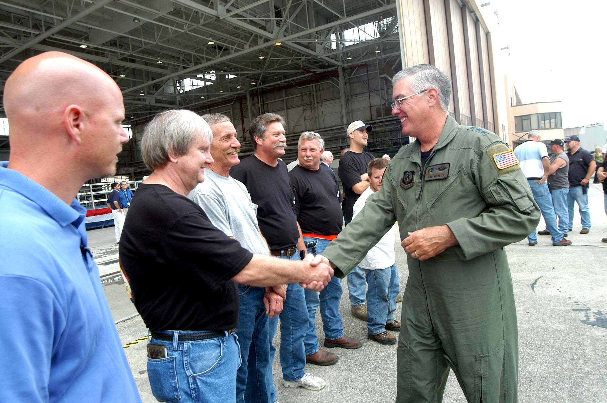 Lt. Gen. Michael W. Wooley thanks Robert Hall and other C-130 aircraft workers at the roll-out ceremony for the MC-130W at Robins Air Force Base, Ga., on Wednesday, June 28. The highly modified C-130 will replace special operations aircraft lost in combat. General Wooley is commander of Air Force Special Operations Command. (U.S. Air Force photo/Sue Sapp)                              