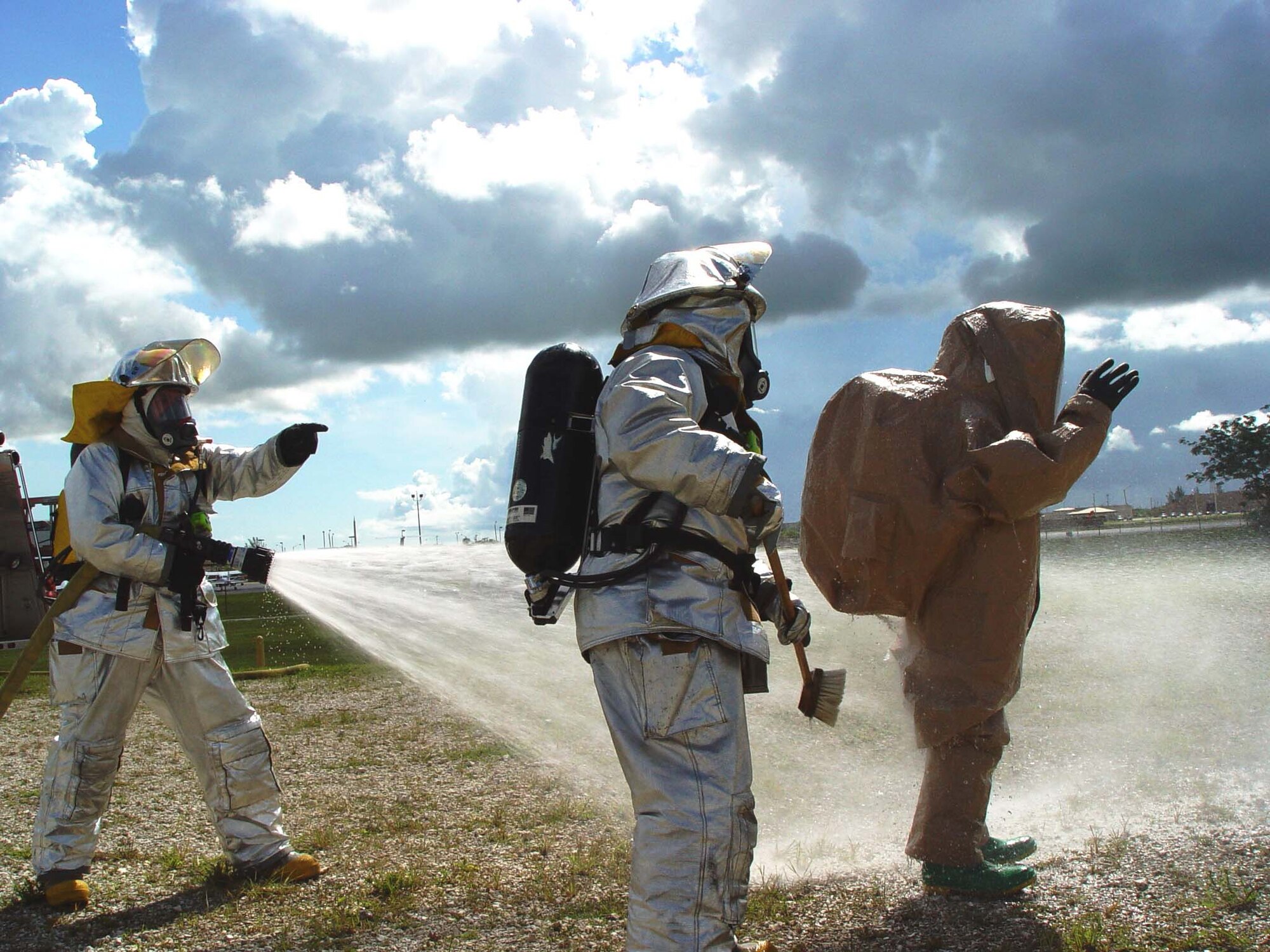 Firefighters from the 482nd Civil Engineering Squadron practice decontamination procedures during hazardous materials training at Homestead Air Reserve Base, Fla. on June 9. Members of the base fire department train several times a year while wearing chemical and biological protective suits.  (US Air Force photo by Lisa Macias)