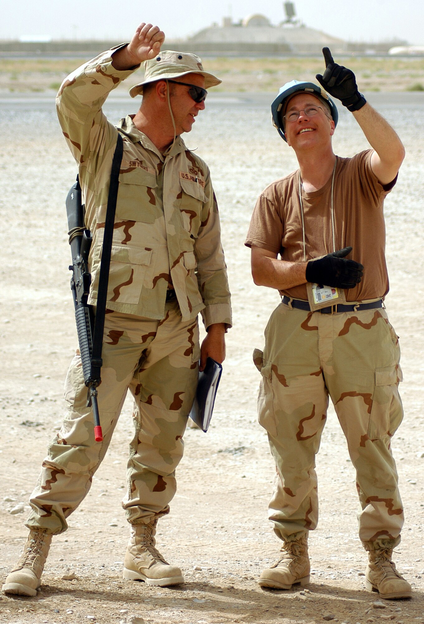 Master Sgts. Frank Swygert, left, and Curtis Conner talk while supervising an engineering team mounting radio antennas to poles for a new air traffic control facility at Kandahar Airfield, Afghanistan. The two sergeants are engineers who overcame shortages of parts and a lack of welding equipment to fabricate parts for the new antennas. (US Air Force photo/Maj. David Kurle)