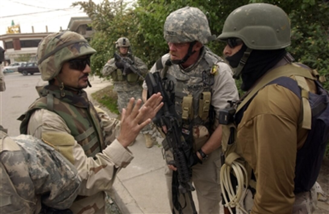An Iraqi translator translates procedures during a joint neighborhood patrol between Iraqi police with a special weapons and tactics team and U.S. Army soldiers from 2nd Battalion, 1st Infantry Regiment, 172nd Infantry Brigade Combat Team in Mosul, Iraq, April 23, 2006. 