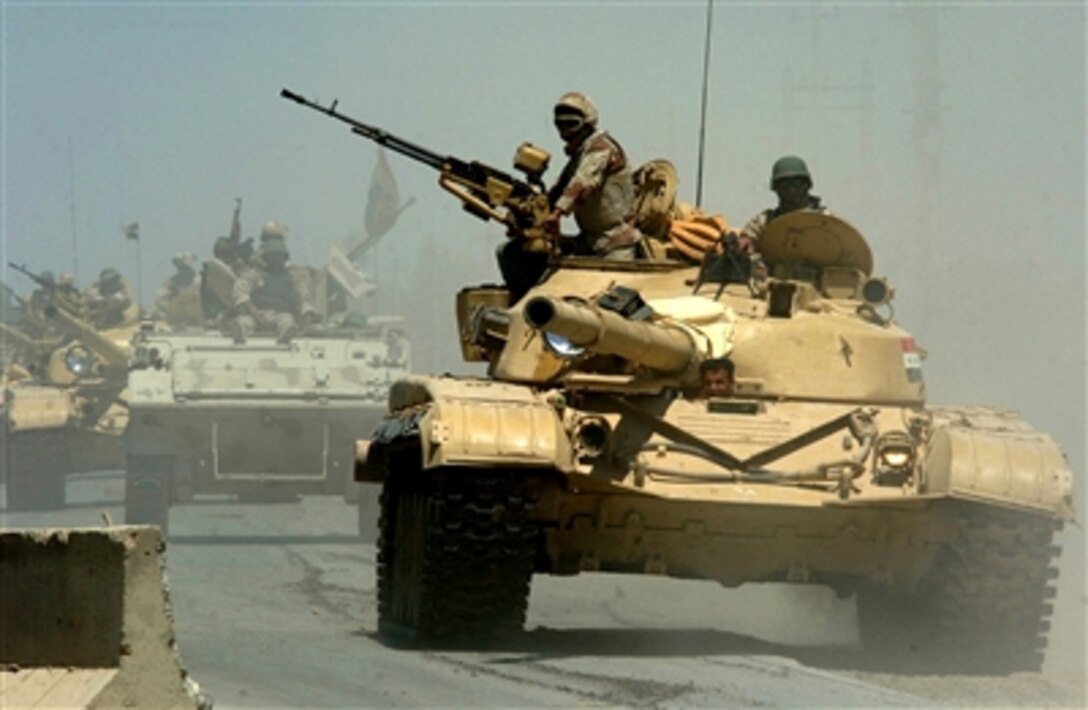 Iraqi army soldiers from the 9th Mechanized Division pass through a highway checkpoint in Mushahada, Iraq, while en route to Camp Taji, Iraq, May 18, 2006. 