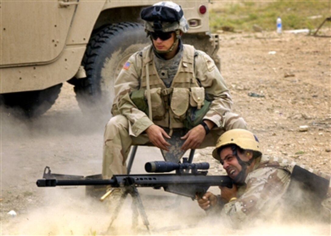 .S. Army Spc. Michael Florczykowski, from the 1st Brigade Combat Team, 1st Armored Division, watches as an Iraqi army soldier fires a Barrett M-107 sniper rifle during joint weapons training in Tall Afar, Iraq, May 18, 2006.