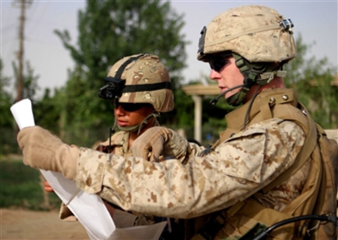 U.S. Marine Cpl. Stephen B. Teeple of Weapons Company, 1st Battalion, 7th Marines shows an Iraqi soldier their location while on patrol in the town of Al Ish, Iraq, during Operation Iraqi Freedom, May 8, 2006. 