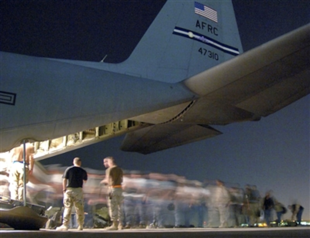 Passengers board a U.S. Air Force Reserve C-130H Hercules aircraft on Sather Air Base, Iraq, April 20, 2006. The aircraft is deployed from the 302nd Airlift Wing, Peterson Air Force Base, Colo. 