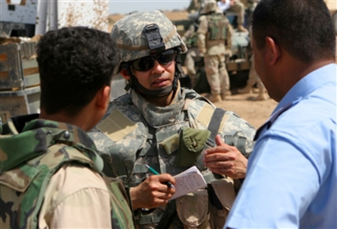 Capt. Alfred Smith of Saint Clair, Pa., stationed with the 2nd Brigade Combat Team, 28th Infantry Division, interviews a translator and a police captain of the West Ramadi Police Station, April 14, 2006. 