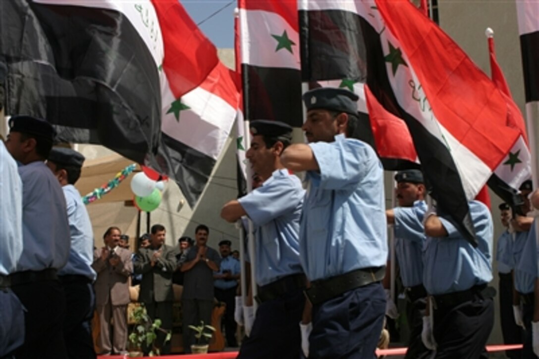 Iraqi policemen conduct a pass in review during the opening ceremony of the Fallujah Police Station, in Fallujah, Iraq, April 13, 2006. 