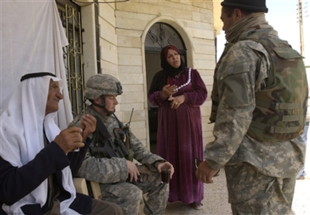 U.S. Army Lt. John Cintron with the 4th Battalion, 23rd Infantry Regiment, 172nd Infantry Brigade Combat Team, speaks to a local resident during a neighborhood patrol in Mosul, Iraq, April 10, 2006. 