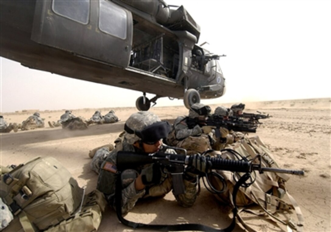 U.S. Army soldiers from the 1st Brigade, 1st Armored Division, dismount a UH-60 Blackhawk helicopter during an air assault in the Al Jazeera Desert, Iraq, March 22, 2006.