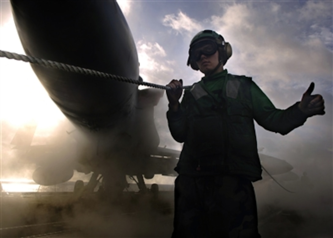 U.S. Navy Airman Jacob Feliciano holds up the safety shot line and signals "all clear" during no-load steam-powered aircraft catapult tests on the flight deck of the nuclear-powered aircraft carrier USS Enterprise in the Atlantic Ocean, March 12, 2006. 