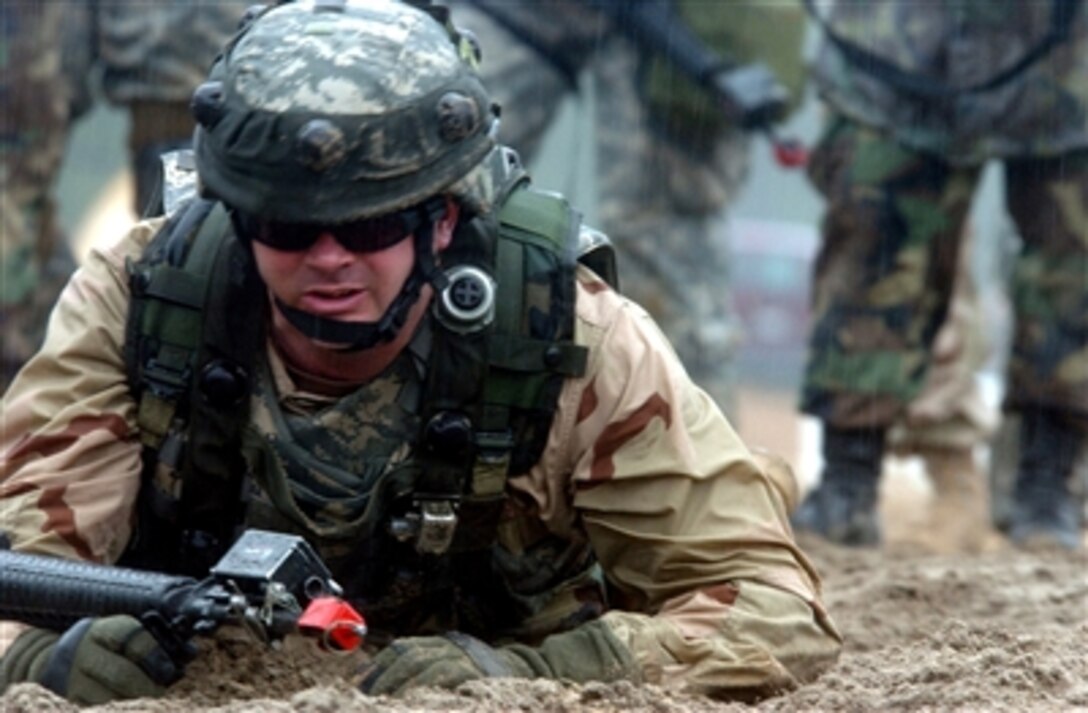 U.S. Navy Petty Officer 1st Class Jeffery Dexter, takes a quick look up from his low crawl as part of Warrior Skills Training at Eastover, S.C., Feb. 22, 2006. Dexter is one of more than 200 sailors being trained by Army cadre.
