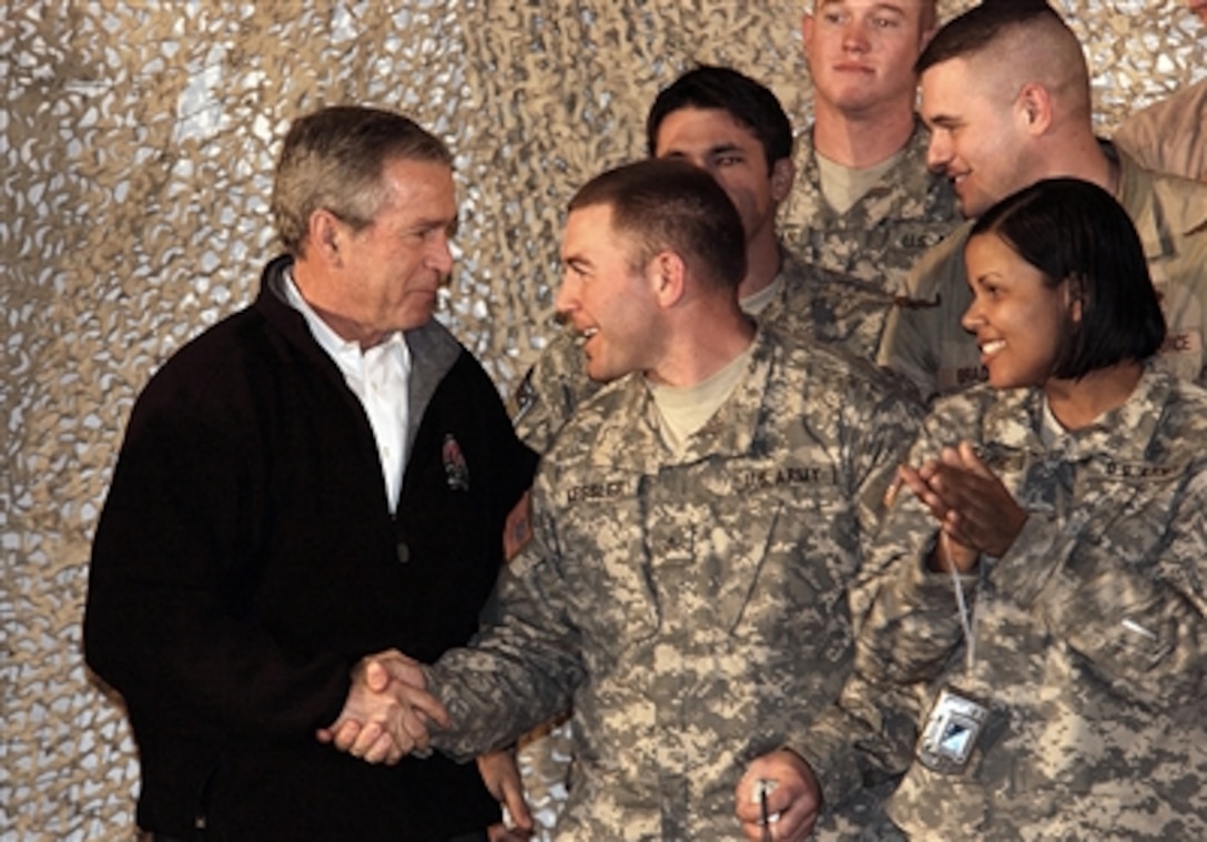 President Bush shakes hands with U.S. Army Sgt. Derek Kessler, 10th Mountain Division Headquarters Company driver, at Bagram Airfield, Afghanistan, March 1, 2006. Bush and first lady Laura Bush made a surprise visit to speak to troops fighting the global war on terrorism. 