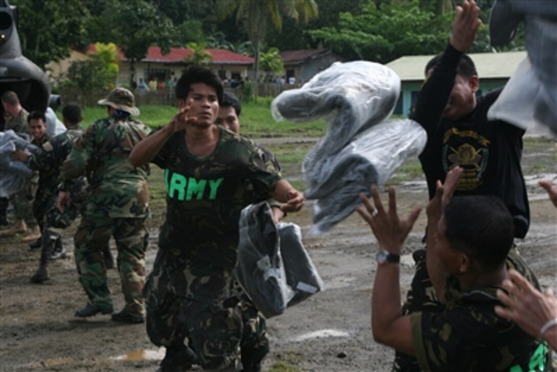 Republic of Philippines army soldiers offload blankets from a U.S. Marine Corps CH-46E Sea Knight helicopter in Leyte, Philippines, Feb. 19, 2006. Humanitarian relief efforts are under way for victims of the Feb. 17, 2006, landslide in the village of Guinsaugon on the island of Leyte. The helicopter is from Marine Medium Helicopter Squadron 262 (Reinforced), 31st Marine Expeditionary Unit.