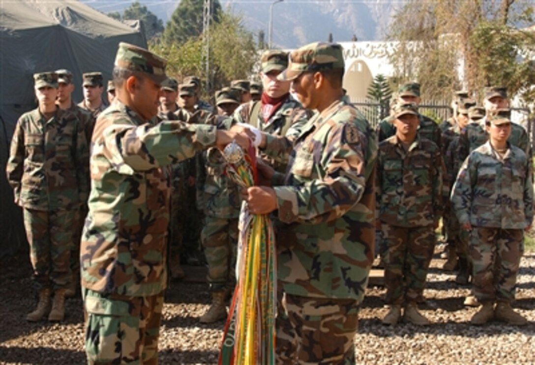 U.S. Army Col. Angel Lugo, commander of the 212th Mobile Army Surgical Hospital, cases the 212th MASH flag during a transfer of authority ceremony in Muzaffarabad, Pakistan, Feb. 16, 2006. The U.S. military is participating in a Pakistani-led relief operation designed to aid victims of the devastating earthquake that struck the region Oct. 8, 2005.
