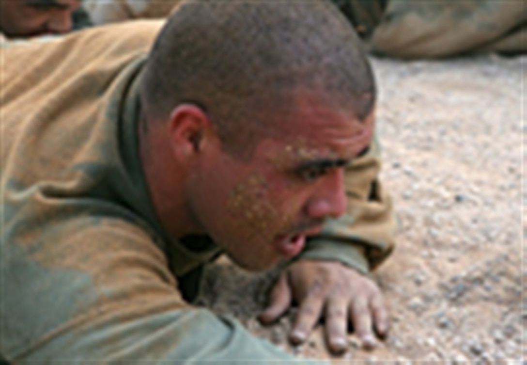 U.S. Marine Corps Lance Cpl. Adam N. Ortiz, with Headquarters Company, Regimental Combat Team 5, low crawls through a sand pit while conducting combat-conditioning drills during Marine Corps Martial Arts Program training on Camp Fallujah, Iraq, April 21, 2006.