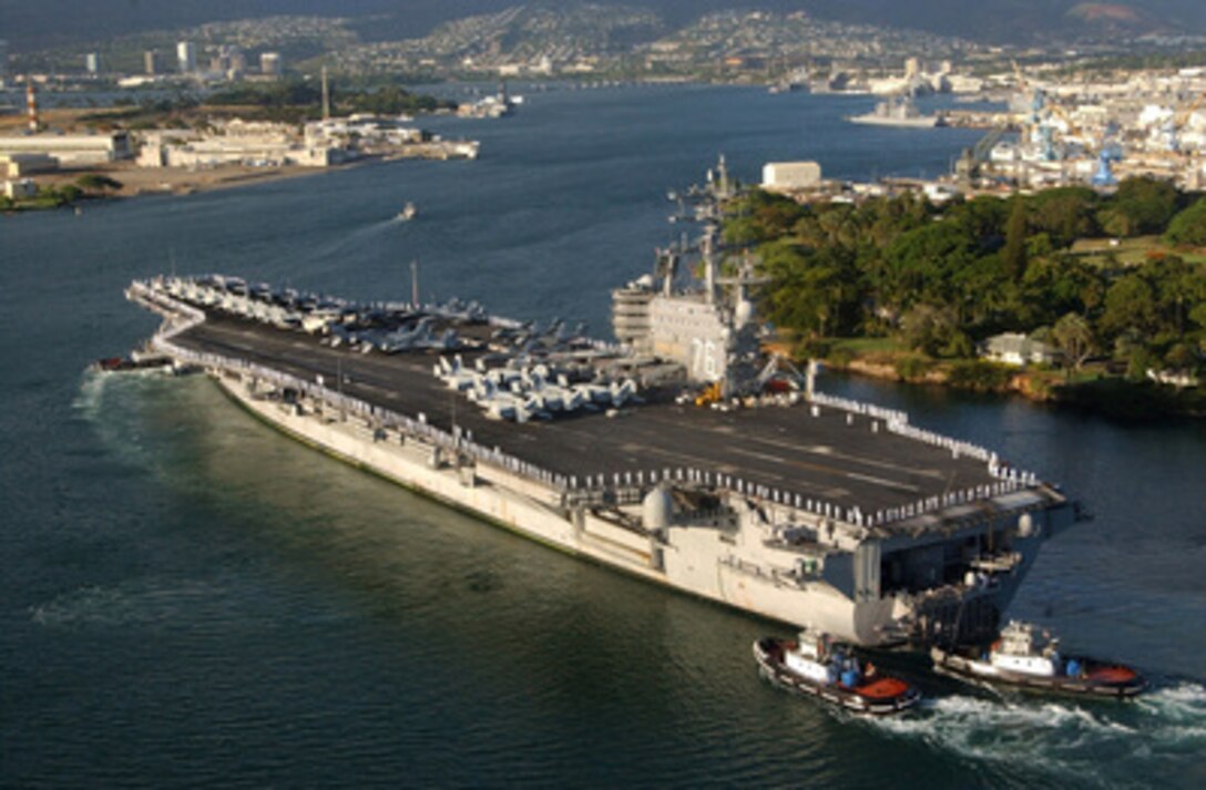The aircraft carrier USS Ronald Reagan (CVN 76) is aided by harbor tugs as it enters Pearl Harbor, Hawaii, for a port visit on June 28, 2006. Reagan and embarked Carrier Air Wing 14 are on a regularly scheduled deployment conducting maritime security operations. 