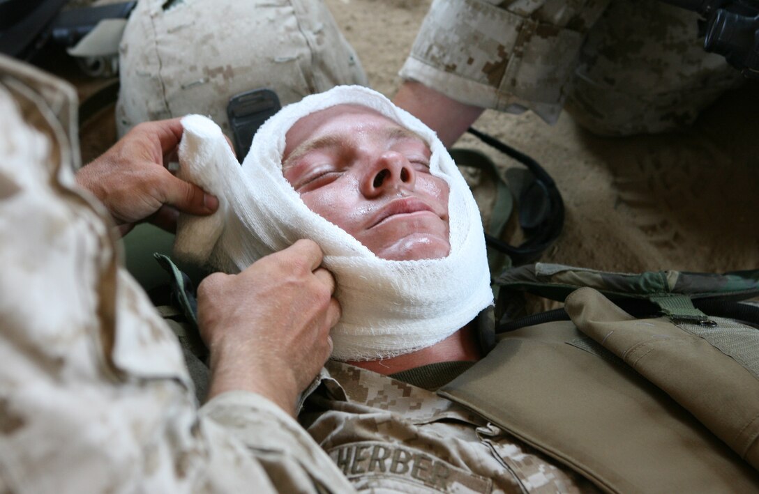 Lance Cpl. Brian R. Herber, machine gunner with Company C, 1st Battalion, 24th Marine Regiment, receives bandages for a ficticious head wound.